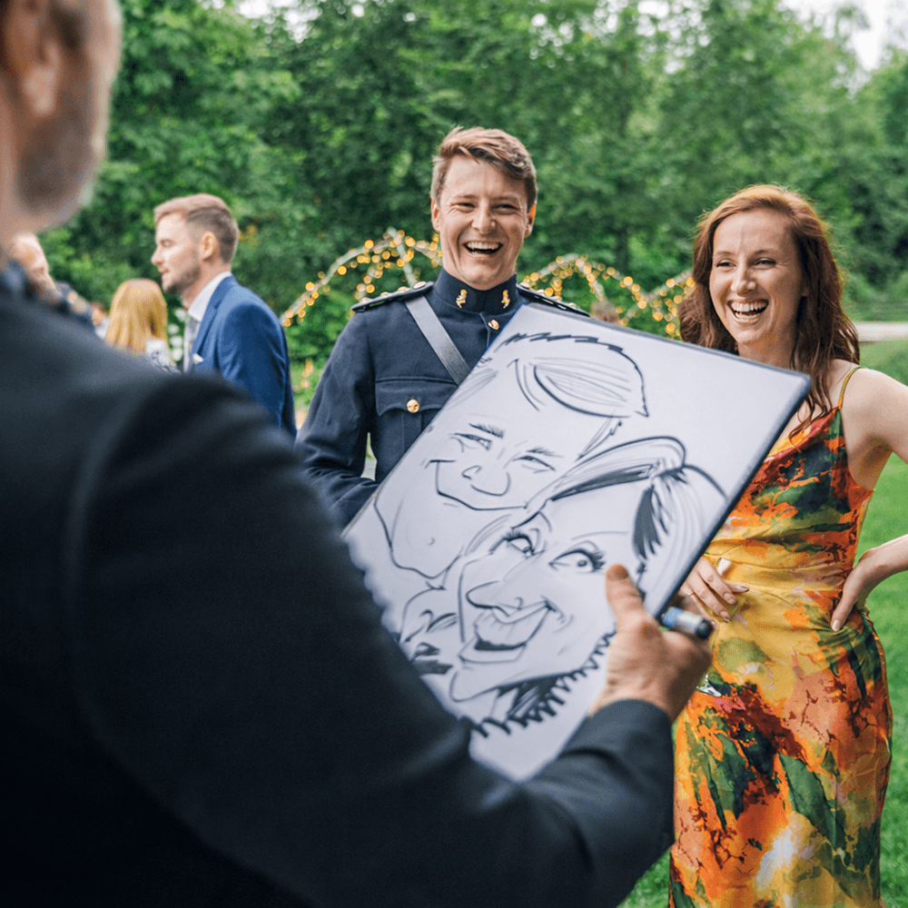 Wedding caricature artist drawing a guest live at a summer event, entertaining a crowd