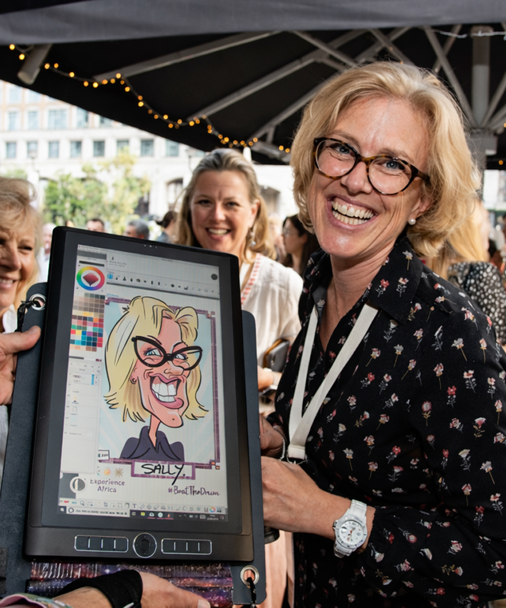 Guest-enjoying-digital-caricature-artwork-at-event-London-2 Event guest holding finished printed digital caricature while viewing artwork on screen