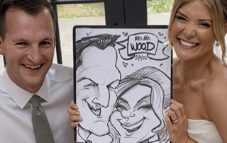 Bride and groom smiling holding a hand-drawn wedding caricature