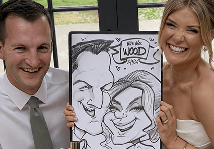 bride-and-groom-laughing-caricature-S Bride and groom smiling holding a hand-drawn wedding caricature