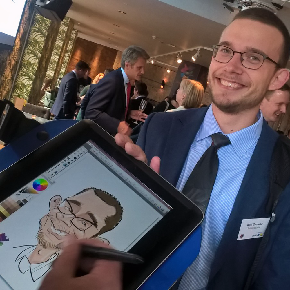 iPad-caricaturist-drawing-guest-at-fun-corporate-event-UK Digital caricature artist working live on iPad with full event setup in place