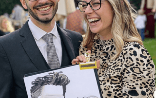 Wedding guests holding their caricature and laughing