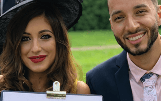 Two wedding guests laughing while holding a caricature drawing