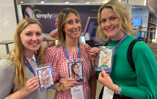 Conference attendees holding branded caricatures at event in Manchester