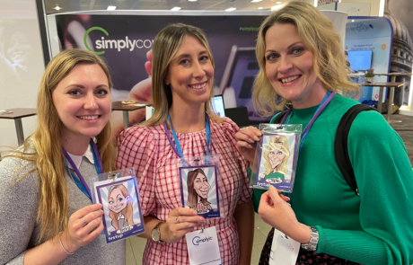 Conference attendees holding branded caricatures at event in Manchester