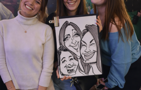Three girls holding their fun caricature