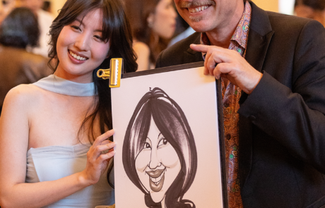 Caricature artist with guest at graduation event