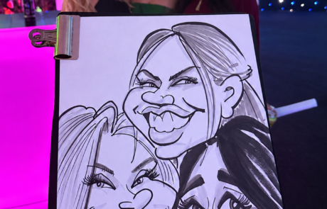 Group of young women at corporate event with their caricature