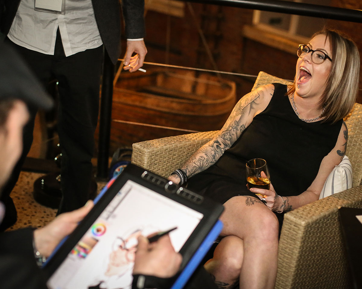 Woman laughing while being drawn at party in UK
